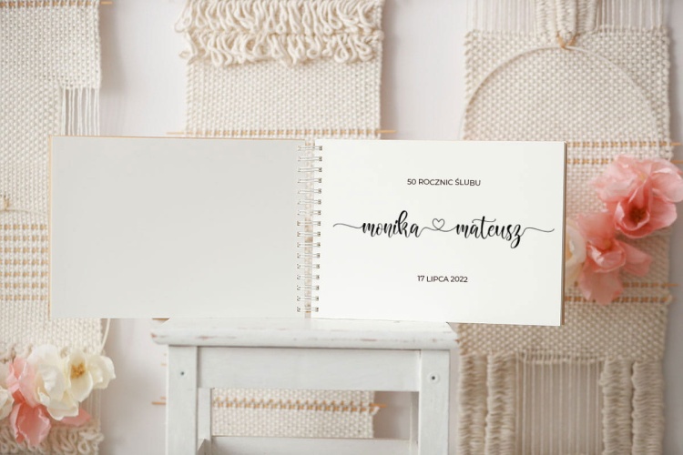 Pierwsza strona drewnianej kroniki 50 rocznic ze wzorem z pisanymi imionami i serduszkiem między nimi