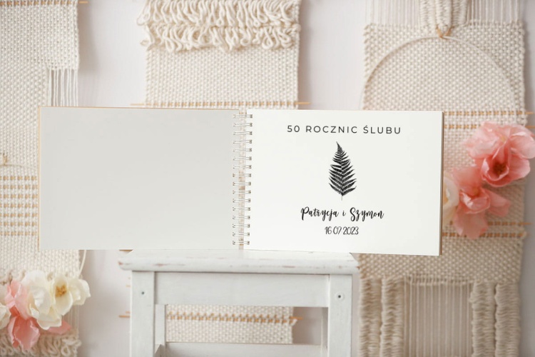 Pierwsza strona drewnianej kroniki z liściem paprotki