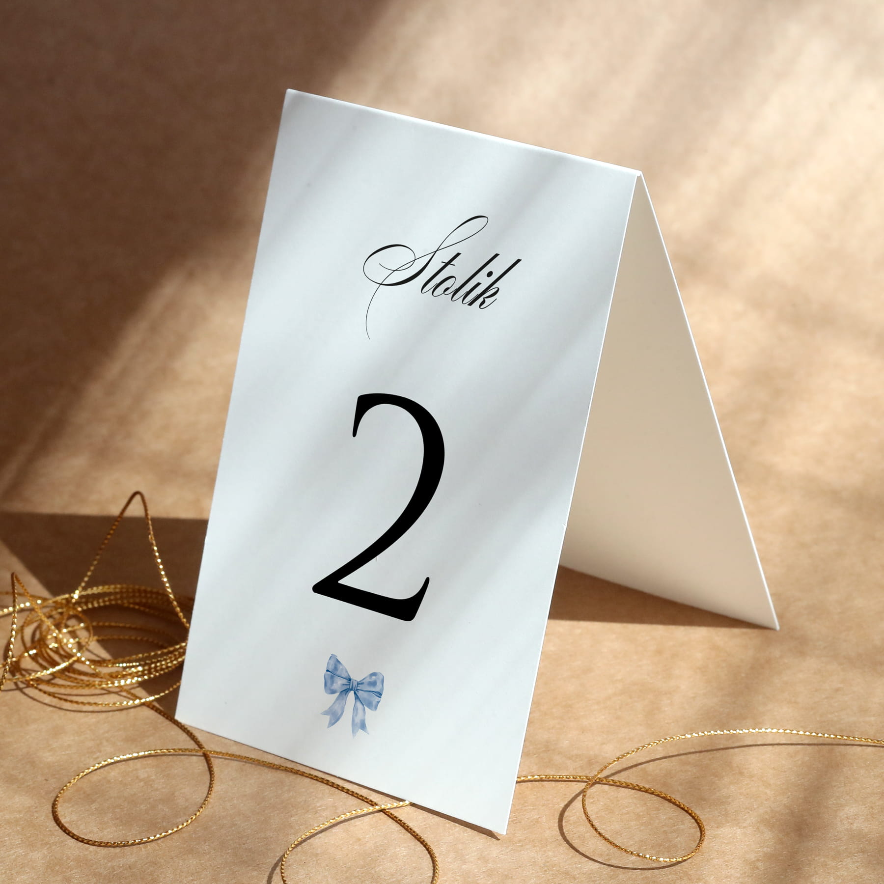 Minimalistyczne numerki na stół urodzinowy z kokardką